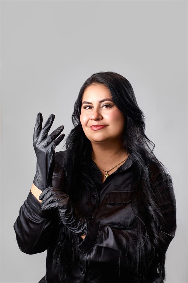 Estilista de cabello se ajusta los guantes negros y sonríe